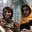 Iranian women show their ink-stained fingers after voting in presidential elections at a polling station in Tehran on May 19, 2017