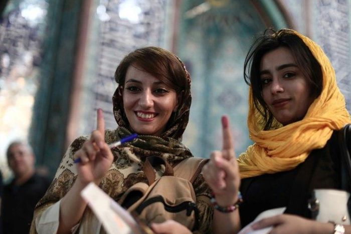 Iranian women show their ink-stained fingers after voting in presidential elections at a polling station in Tehran on May 19, 2017