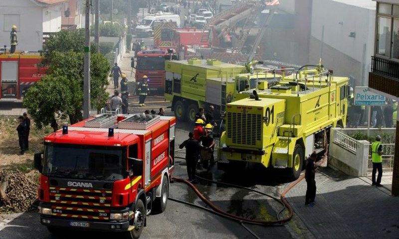 Rescue crews work after a plane crashed into a supermarket warehouse in Tires, near Sintra on April 17, 2017