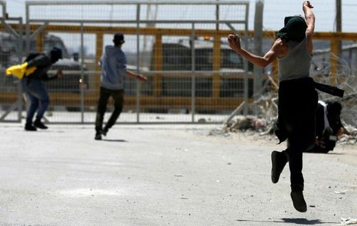 Palestinian protesters hurl stones towards Israeli security forces during clashes following a demonstration in solidarity with hunger-striking Palestinian prisoners, in front of Ofer prison in the West Bank, on April 20, 2017