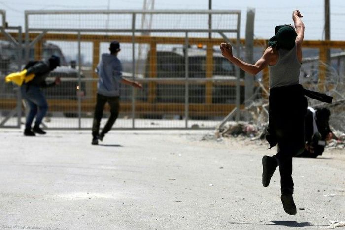 Palestinian protesters hurl stones towards Israeli security forces during clashes following a demonstration in solidarity with hunger-striking Palestinian prisoners, in front of Ofer prison in the West Bank, on April 20, 2017