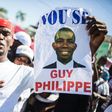 A supporter of Guy Philippe holds a sign during protests in front of the US embassy in Tabarre, Haiti in January 2017