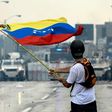A Venezuelan opposition demonstrator waves a national flag in front of the riot police during a protest against President Nicolas Maduro, in Caracas, on May 8, 2017
