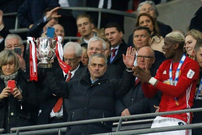 Manchester United's manager Jose Mourinho holds up the trophy as Manchester United players celebrate their victory after the English League Cup final football match between Manchester United and Southampton at Wembley stadium on February 26, 2017
