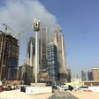 Smoke billows near the Dubai Mall and Burj Khalifa, the world's tallest building, after a fire hit the construction site in Dubai on April 2, 2017