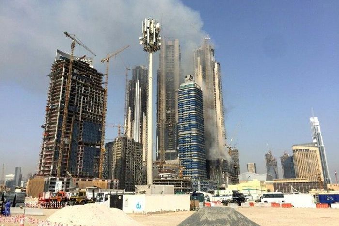 Smoke billows near the Dubai Mall and Burj Khalifa, the world's tallest building, after a fire hit the construction site in Dubai on April 2, 2017