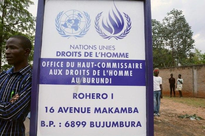 A man stands by a sign outside the UN Commission on Human Rights headquarters in Burundi as people demonstrate against the EE, the ICC and the Resolution against Burundi in Bujumbura on October 8, 2016