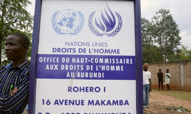A man stands by a sign outside the UN Commission on Human Rights headquarters in Burundi as people demonstrate against the EE, the ICC and the Resolution against Burundi in Bujumbura on October 8, 2016
