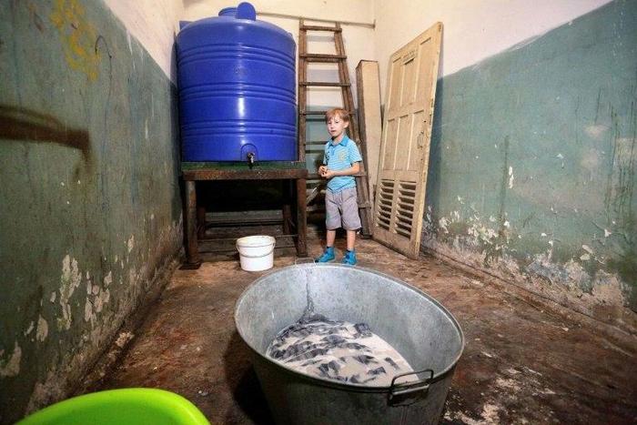 Sasha, 10, stands in a bomb shelter in Donetsk, eastern Ukraine, on September 19, 2016, where he hides with his mother Elena