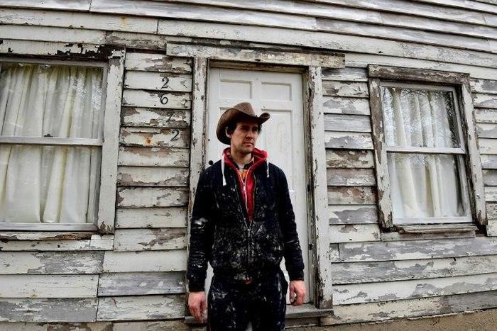 Artist Ryan Mendoza poses in front of Rosa Parks' house during which he helped rescue from Detroit and rebuilt it in his garden