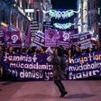 People hold signs as they march down Istiklal Avenue during a feminist night march to mark International Women's Day in Istanbul on March 8, 2017