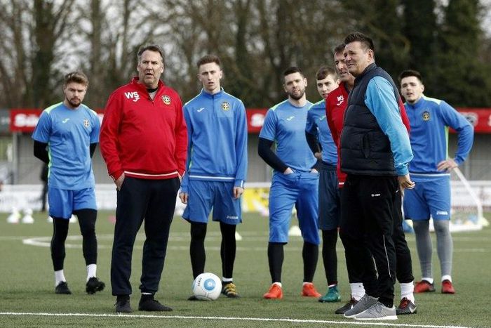 Sutton United's English manager Paul Doswell (R) and former Arsenal player Paul Merson (2L) stand on the pitch with the players during a team training session in Sutton, sout-west London, on February 16, 2017