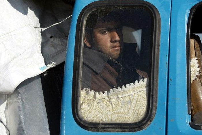 A displaced Syrian man waits inside a truck carrying his family's belongings at a checkpoint near the town of Manbij, northern Syria on March 6, 2017