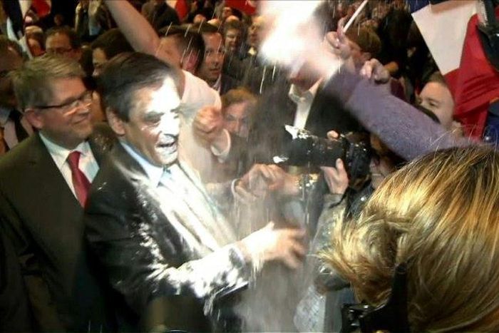 French presidential election candidate for the right-wing Les Republicains (LR) party Francois Fillon (C) reacting as a man throw flour at him on April 6, 2017 during a political rally in Strasbourg, northeastern France