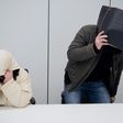 Defendants hide their faces at a regional court in Hildesheim, central Germany, on February 8, 2017