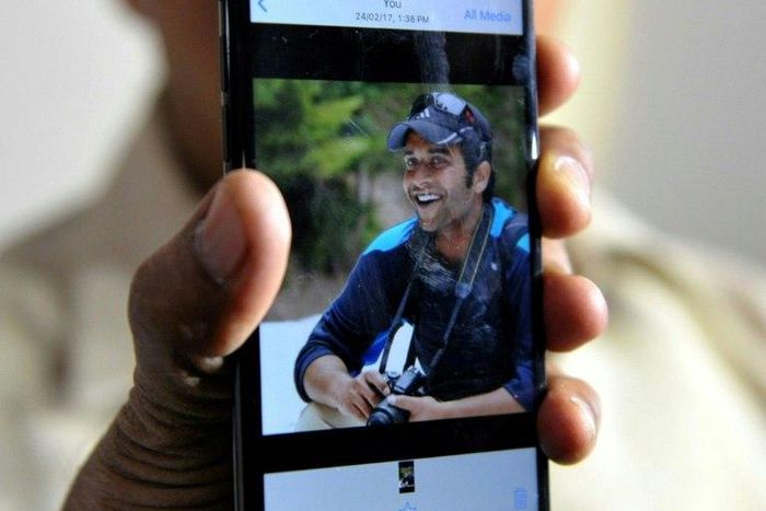 Jagan Mohan Reddy holds a smartphone with an image of his son Alok Madasani at his residence in Hyderabad on February 24, 2017, after Alok was injured in the shooting of two Indian men in the US state of Kansas