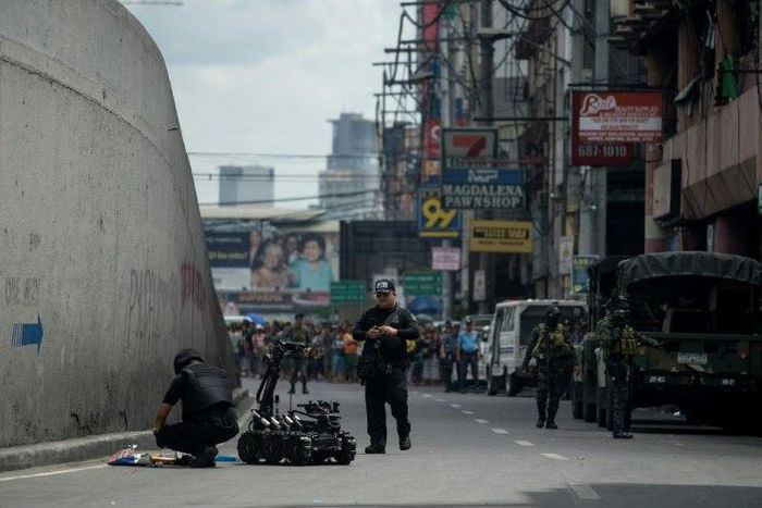 Bomb squad operatives and a bomb disposal robot inspect a suspicious package in Quiapo, Manila on May 7, 2017