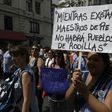 A teacher holds a placard reading "While there are teachers standing, there will be no people on their knees" during a 48-hour nationwide strike demanding pay rises, in Buenos Aires on March 6, 2017