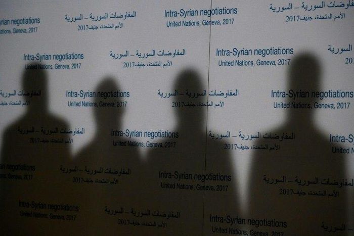 Shadows of members of Syria's main opposition High Negotiations Committee are casted on a backdrop during a press conference on Syria peace talks on February 27, 2017, in Geneva