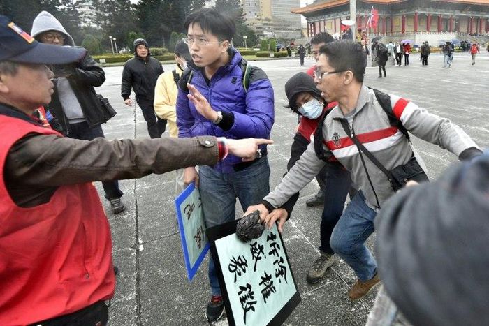 An activist (left) favouring unification with China clashes with pro-unification activists on the 70th anniversary of the 228 incident at the Chiang Kai-shek Memorial Hall in Taipei on February 28, 2017