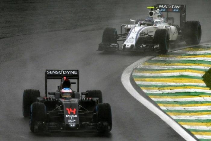 McLaren-Honda's driver Fernando Alonso (front) powers his car during the Brazilian Grand Prix at the Interlagos circuit in Sao Paulo, Brazil, on November 13, 2016