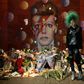 A fan poses in front of the mural of late British pop icon David Bowie created by Australian street artist James Cochran, as fans payed their respects in Brixton, south London on January 10, 2017, on the first anniversary of Bowie's death