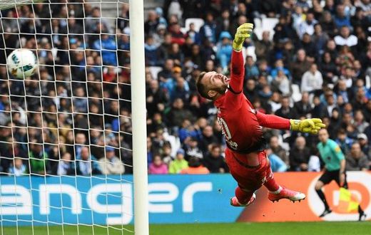 Dijon's Baptiste Reynet fails to stop a shot by Marseille's Dimitri Payet during their match at the Velodrome stadium in Marseille on April 1, 2017