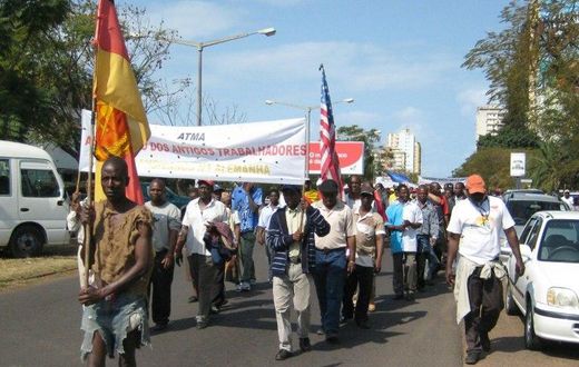 Demonstrators carrying a banner reading "Association of Former Mozambican Workers in Germany" march in Maputo over unpaid wages