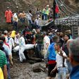 Rescuers carry a corpse following deadly mudslides in the central Colombian city of Manizales