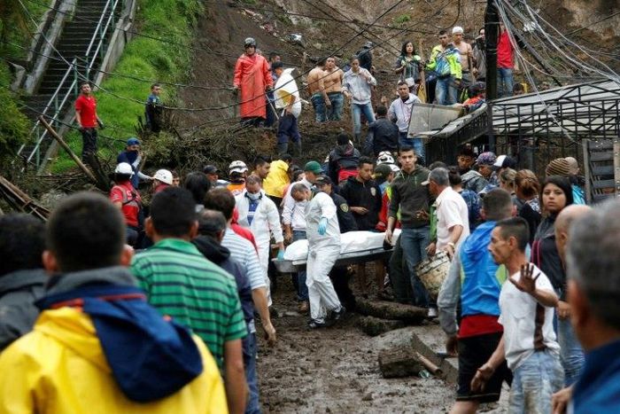 Rescuers carry a corpse following deadly mudslides in the central Colombian city of Manizales