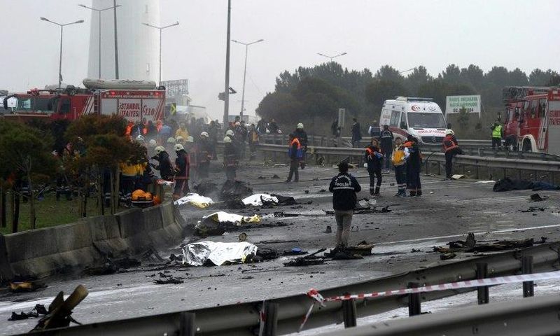 Firefighters work at helicopter crash site in Istanbul on March 10, 2017 as bodies lie covered with blankets