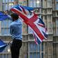 A man waves both a Union flag and a European flag outside the Houses of Parliament at an anti-Brexit protest in central London on June 28, 2016shortly after the referendum ended with a British vote to leave the EU