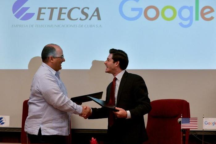 Cuban state-run Telecommunications Company ETECSA's investments vice-president, Luis Adolfo Iglesias Reyes (L), and the head of Google Cuba, Brett Perlmutter (R), shake hands after signing a memorandum of understanding at the Miramar Trade Center in Ha...