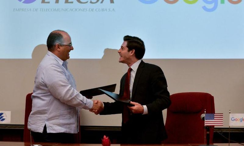 Cuban state-run Telecommunications Company ETECSA's investments vice-president, Luis Adolfo Iglesias Reyes (L), and the head of Google Cuba, Brett Perlmutter (R), shake hands after signing a memorandum of understanding at the Miramar Trade Center in Ha...