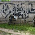 Police officers and soldiers paint over graffiti associated with the Mara Salvatrucha gang in Quezaltepeque, El Salvador