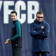 Barcelona's Sergio Busquets (L) smiles past Barcelona's coach Luis Enrique during a training session on December 5, 2016