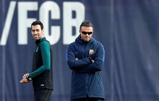 Barcelona's Sergio Busquets (L) smiles past Barcelona's coach Luis Enrique during a training session on December 5, 2016
