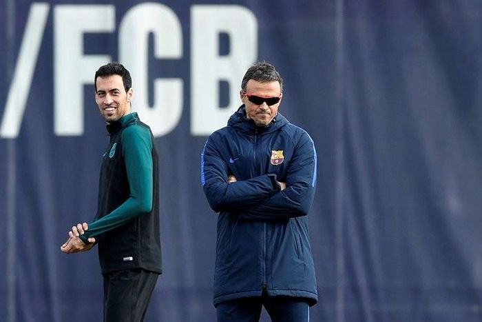 Barcelona's Sergio Busquets (L) smiles past Barcelona's coach Luis Enrique during a training session on December 5, 2016