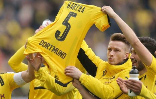 Dortmund's Marco Reus holds the jersey of teammate Marc Bartra who was injured during attack on the team's bus after their German First division Bundesliga match against Eintracht Frankfurt, in Dortmund, on April 15, 2017