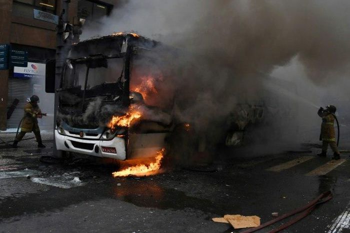 Civil servants protesting against austerity measures clash with riot police and set fire to a bus on Rio Branco, the main avenue in Rio de Janeiro, Brazil, while firefighters attempt to put out the blaze, on February 1, 2017