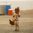 A displaced child, who fled from the Islamic State group bastion of Raqa, stands outside as she eats a loaf of bread in a camp for displaced near the town of Al-Karamah, 26 kilometres from Raqa, on May 10, 2017