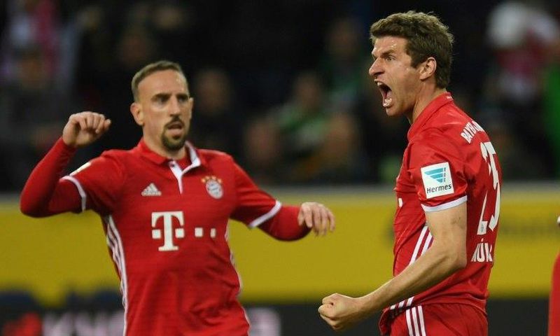 Bayern Munich's midfielder Thomas Mueller (R) celebrates a goal on March 19, 2017