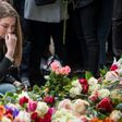 A woman reacts during a minute of silence to commemorate the victims of Friday's terror attack at a makeshift memorial near the site where a truck drove into Ahlens department store in Stockholm, Sweden, on April 10, 2017