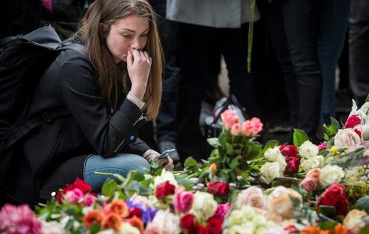 A woman reacts during a minute of silence to commemorate the victims of Friday's terror attack at a makeshift memorial near the site where a truck drove into Ahlens department store in Stockholm, Sweden, on April 10, 2017