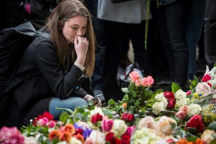 A woman reacts during a minute of silence to commemorate the victims of Friday's terror attack at a makeshift memorial near the site where a truck drove into Ahlens department store in Stockholm, Sweden, on April 10, 2017