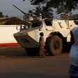 Women walk by a United Nations peacekeeping armoured vehicle guarding the outer perimeter of a compound of a school used as an electoral centre at the end of the presidential and legislative elections, in the mostly muslim PK5 neighbourhood of Bangui, ...