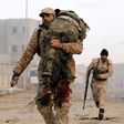 A member of the Libyan National Army (LNA) carries an injured comrade during fighting against jihadists in Qanfudah, on the southern outskirts of Benghazi