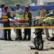 Pakistani security officials collect evidence from the scene of an attack on a census team in Lahore