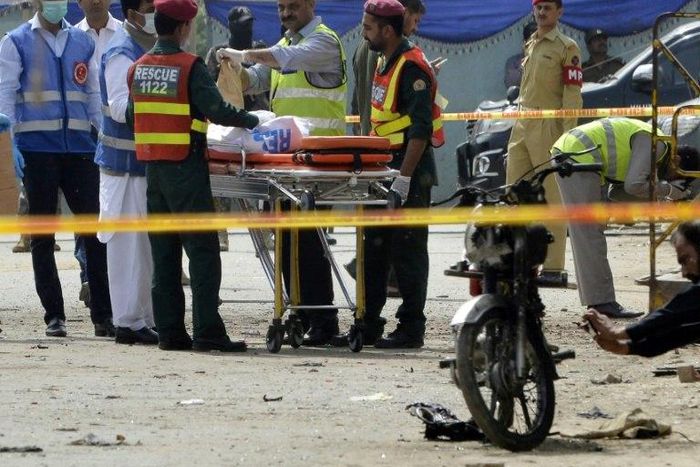 Pakistani security officials collect evidence from the scene of an attack on a census team in Lahore