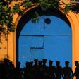 Sri Lankan policemen stand guard in front of protesters outside the main prison in Colombo on August 8, 2011